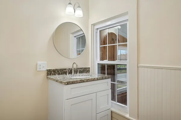 a bathroom with a granite countertop sink and a mirror