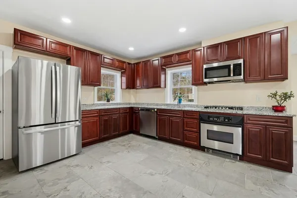 a kitchen with stainless steel appliances granite countertop a refrigerator stove top oven and sink