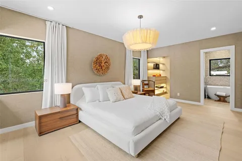 a bedroom with a bed and a large window