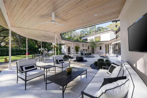 a outdoor space with couches a barbecue grill a dining table and chairs with outer view