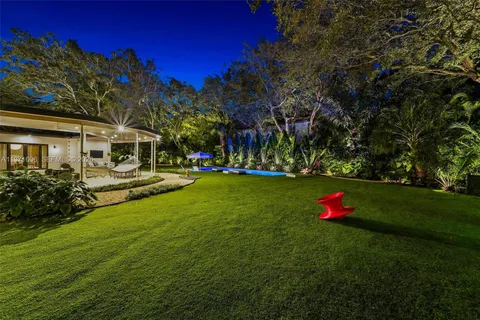 a view of a white house that has a tree