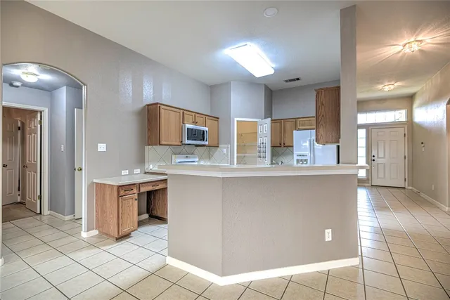 a large kitchen with stainless steel appliances a stove a sink cabinets and a counter top space