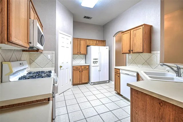 a kitchen with a sink a stove top oven and cabinets