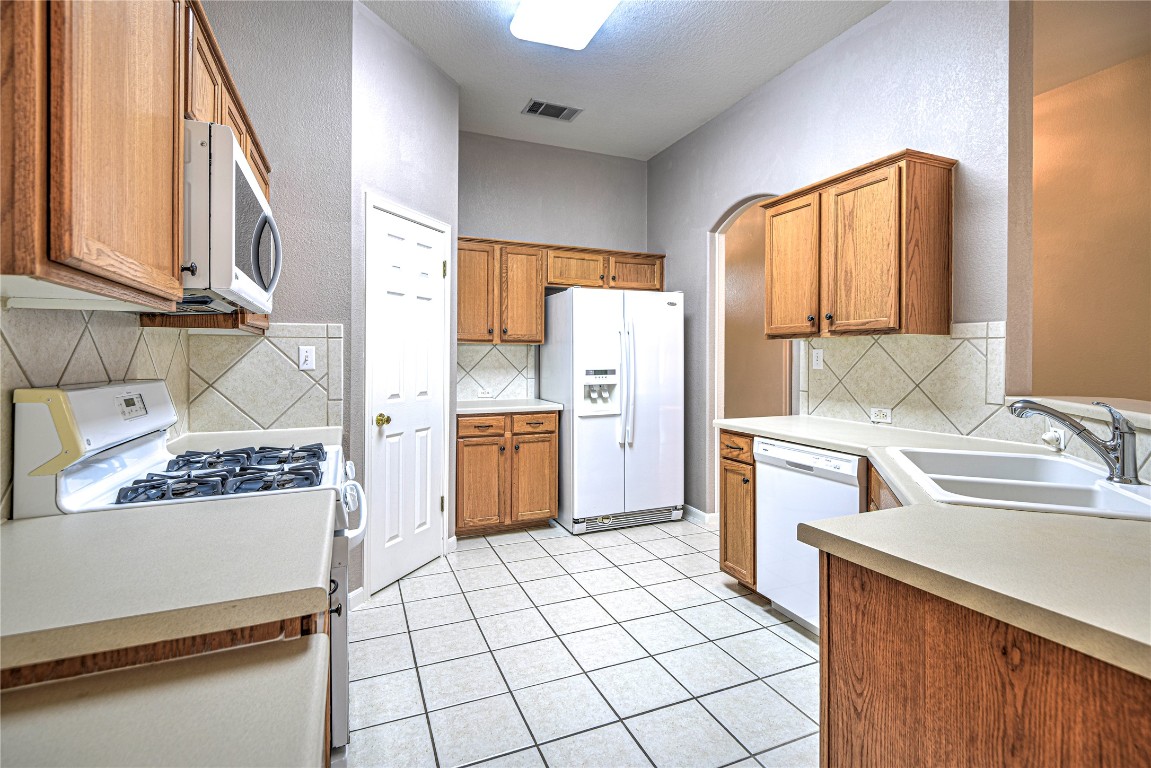1900 Rutherford Drive Leander, TX 78641 - Photo 17 of 38 a kitchen with a sink a stove top oven and cabinets