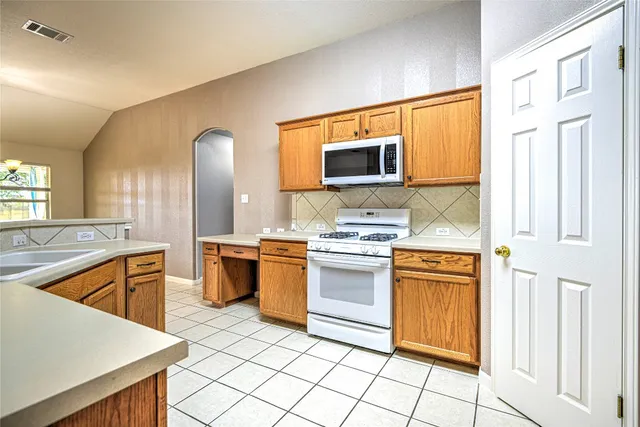 a kitchen with stainless steel appliances granite countertop a sink and a stove top oven