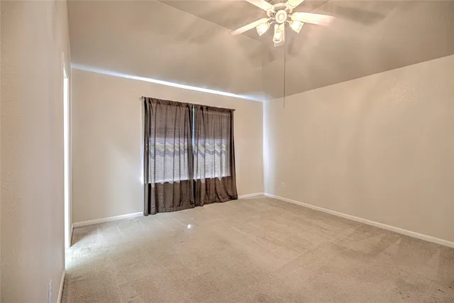 a view of a livingroom with a chandelier fan and window