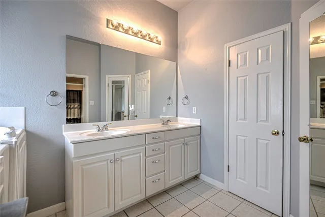 a spacious bathroom with a granite countertop sink a mirror and a