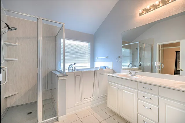 a spacious bathroom with a shower sink and mirror