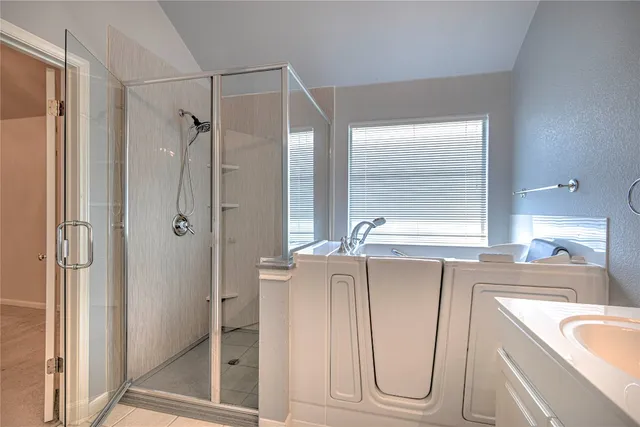 a bathroom with a tub sink and mirror