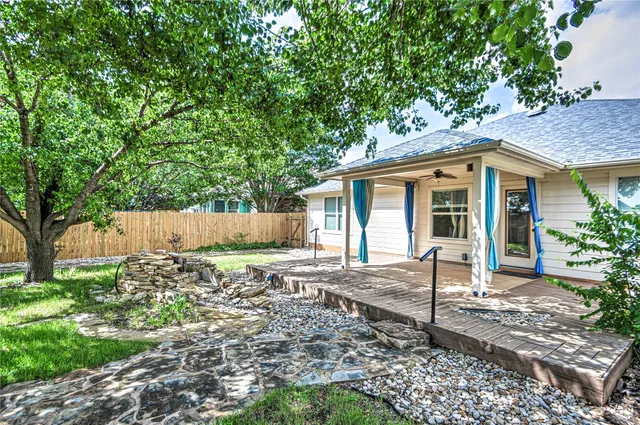 a front view of a house with a tree