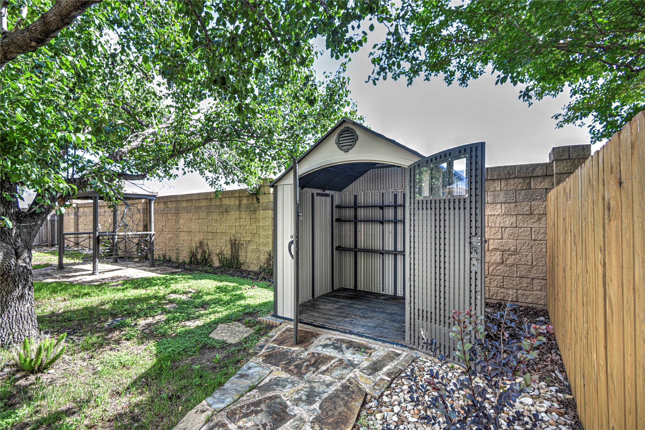 1900 Rutherford Drive Leander, TX 78641 - Photo 35 of 38 a view of a small yard in front of a house with a large tree and wooden fence