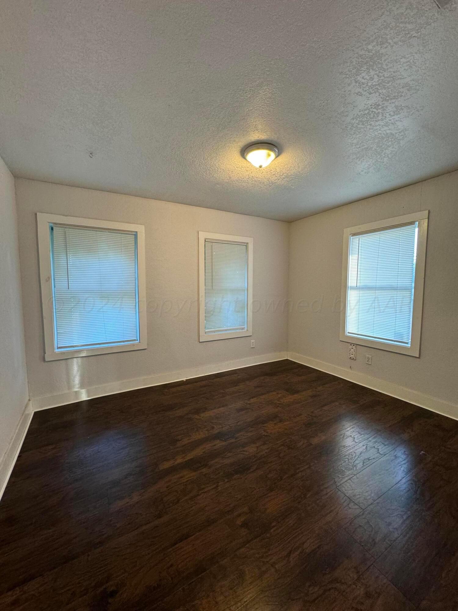 3800 South Polk Street Amarillo, TX 79110 - Photo 11 of 18 a view of an empty room with wooden floor and a window