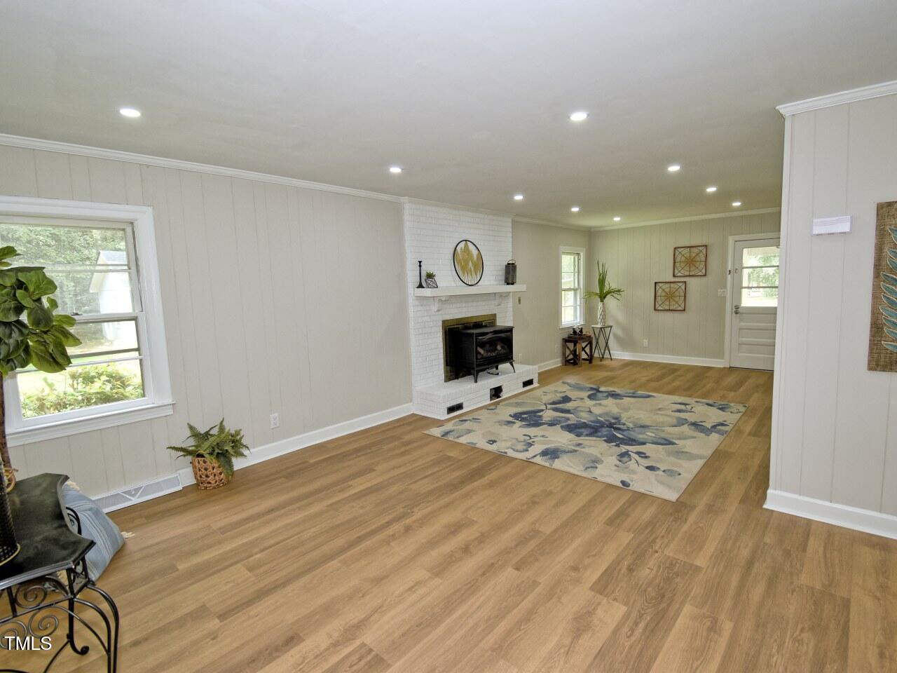 906 Perry Road Zebulon, NC 27597 - Photo 13 of 36 a view of a livingroom with wooden floor and a kitchen
