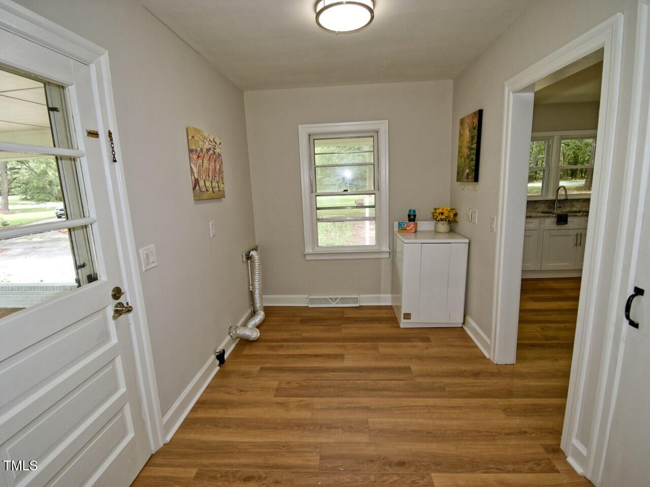 906 Perry Road Zebulon, NC 27597 - Photo 18 of 36 a view of an empty room with wooden floor and a window