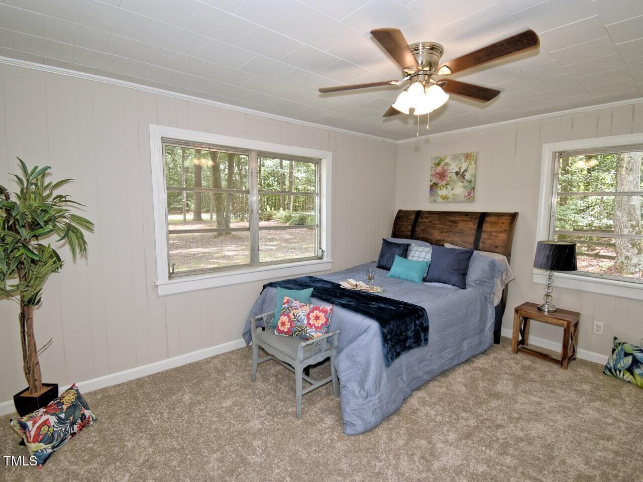 906 Perry Road Zebulon, NC 27597 - Photo 19 of 36 a bedroom with a bed and a chandelier
