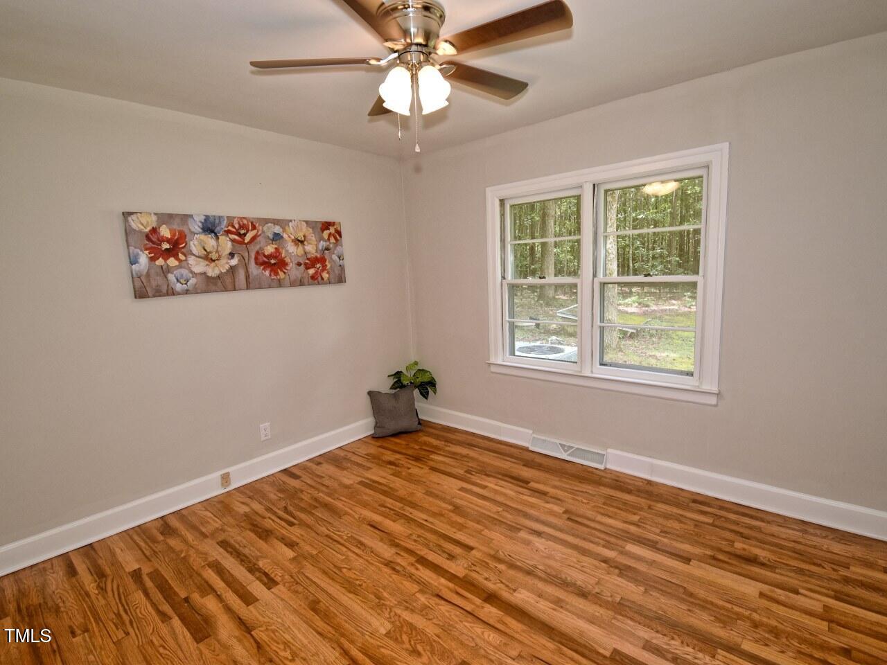 906 Perry Road Zebulon, NC 27597 - Photo 22 of 36 a view of an empty room with wooden floor and a window