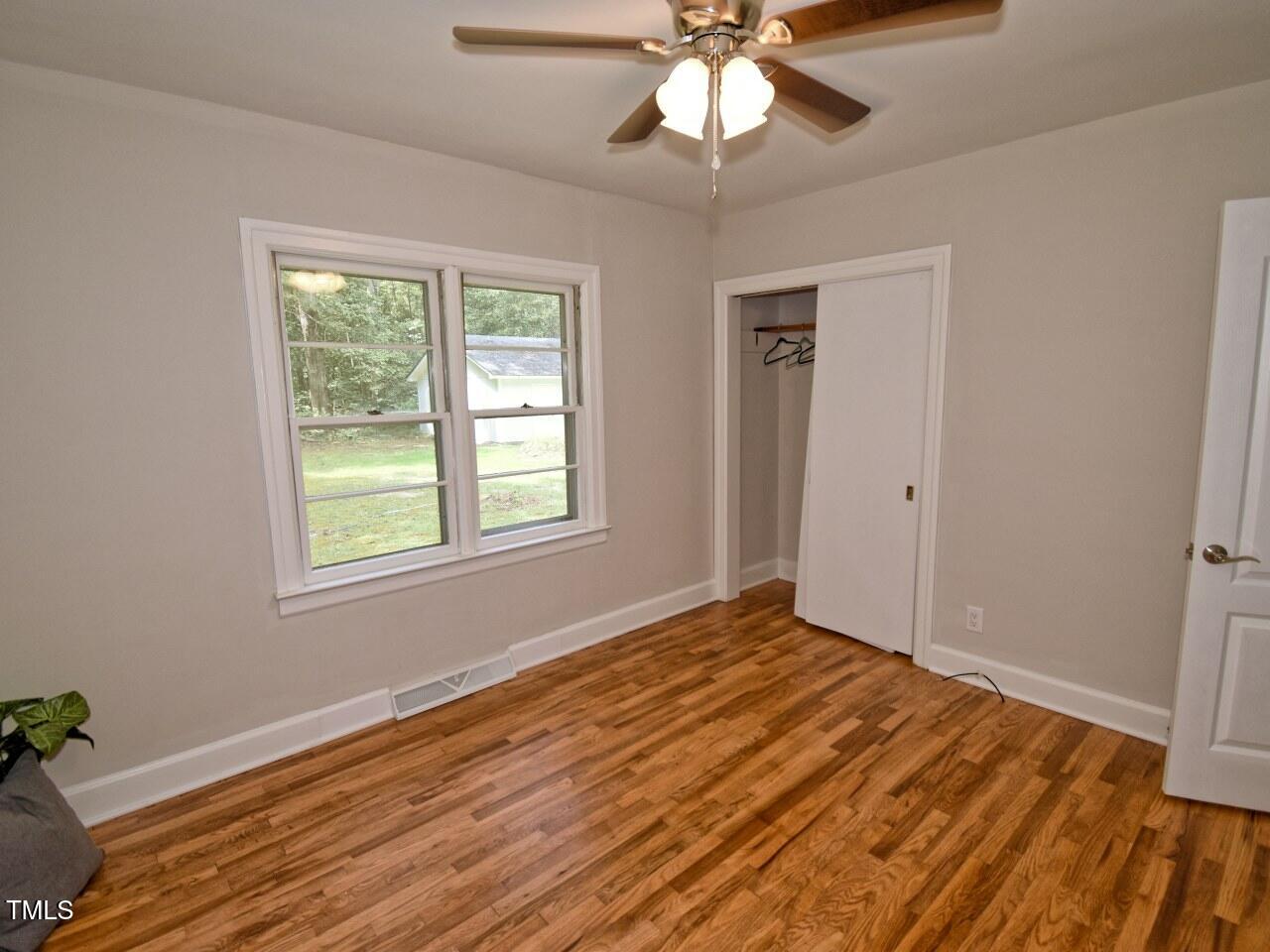 906 Perry Road Zebulon, NC 27597 - Photo 23 of 36 a view of an empty room with wooden floor and a window