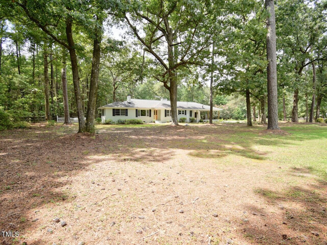 906 Perry Road Zebulon, NC 27597 - Photo 26 of 36 a view of a house with a big yard and large trees