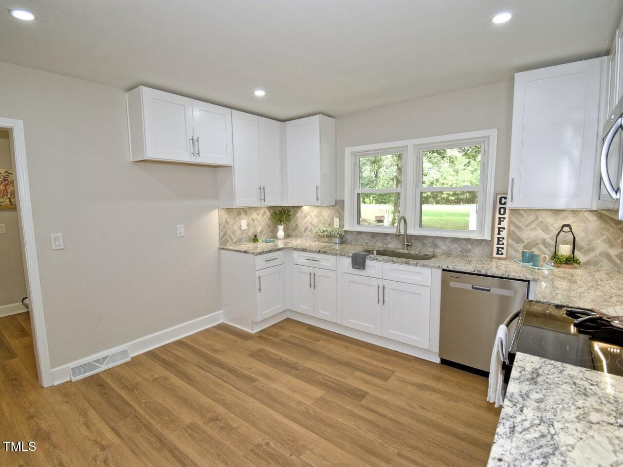 906 Perry Road Zebulon, NC 27597 - Photo 8 of 36 a kitchen with a sink window and cabinets