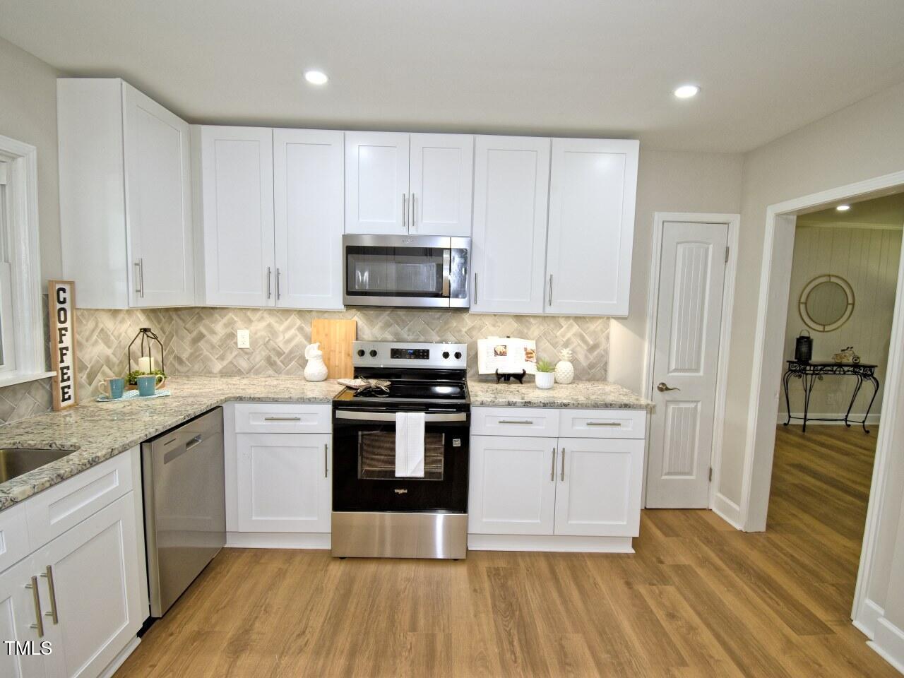 906 Perry Road Zebulon, NC 27597 - Photo 9 of 36 a kitchen with granite countertop a stove and a sink