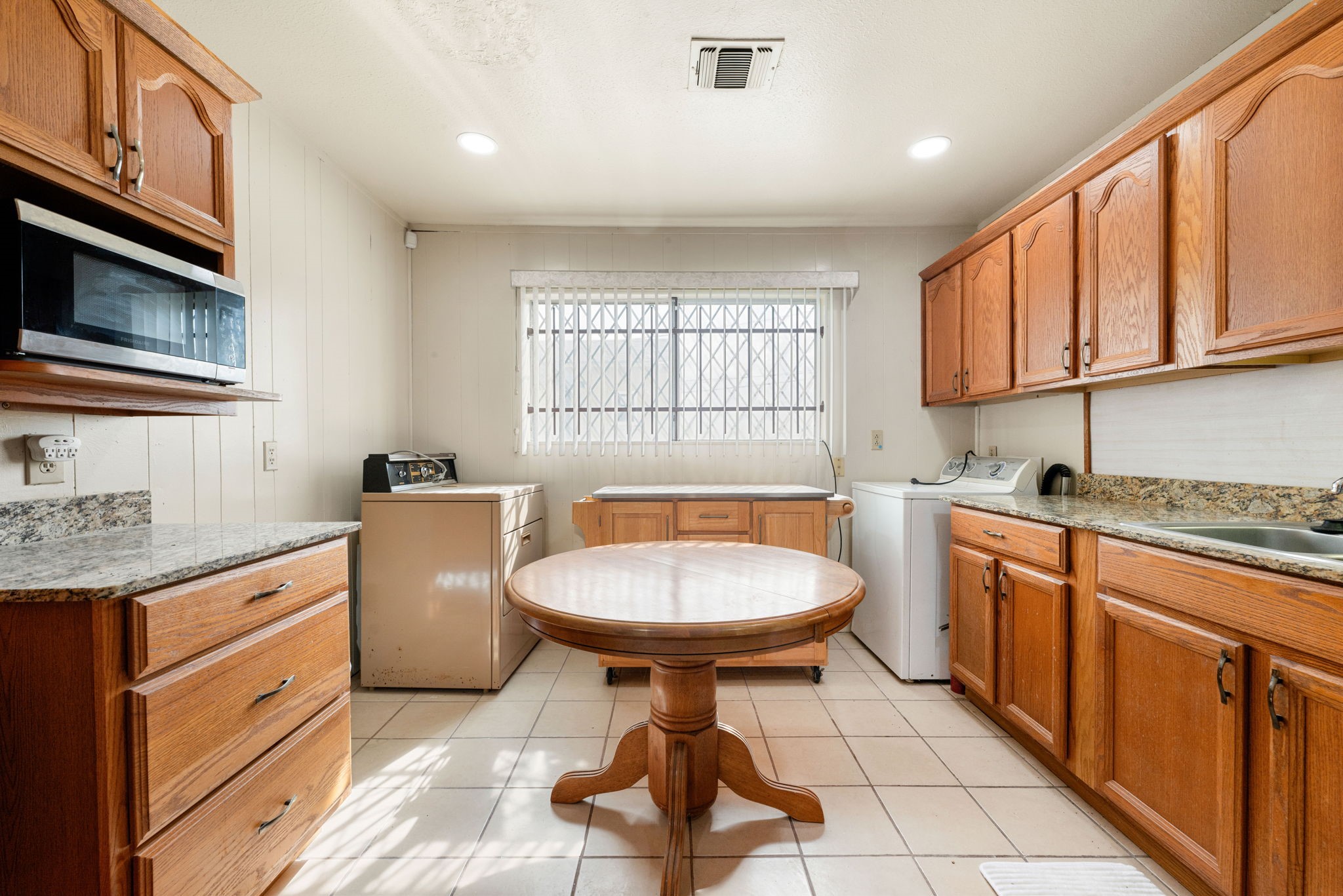 10923 Duane Street Houston, TX 77047 - Photo 17 of 22 a kitchen with a sink a stove cabinets and a window