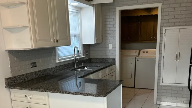 a bathroom with a granite countertop sink and a bathtub