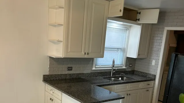 a kitchen with granite countertop a sink and a stove