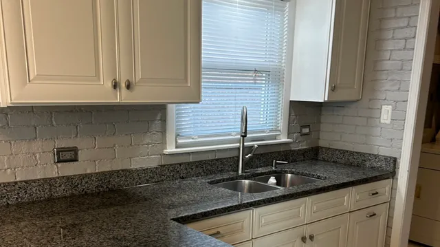 a kitchen with granite countertop a sink and a stove
