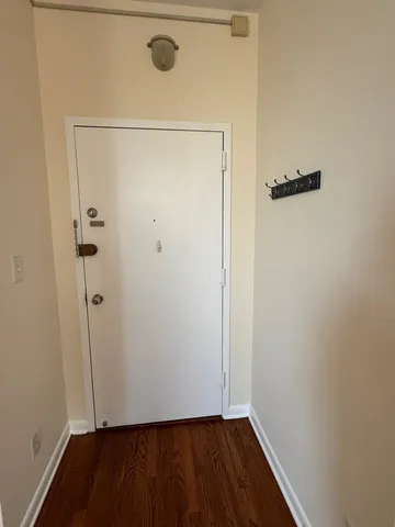 a view of a room with wooden floor and a window