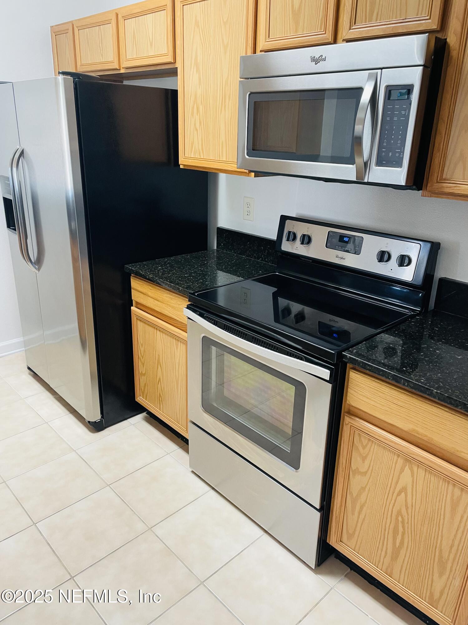 7990 Baymeadows Road East, Unit 426 Jacksonville, FL 32256 - Photo 2 of 19 a kitchen with granite countertop a stove and a microwave