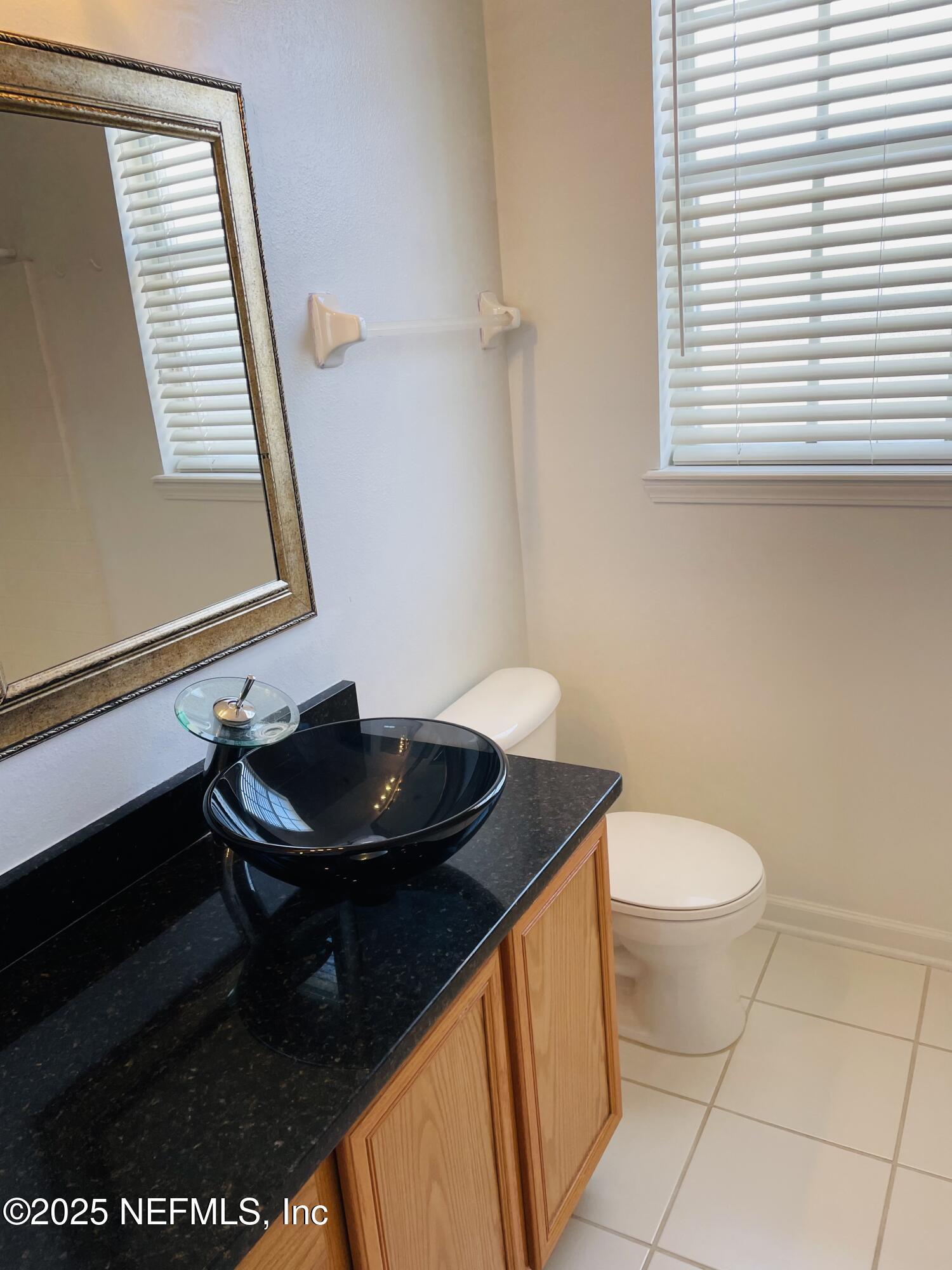 7990 Baymeadows Road East, Unit 426 Jacksonville, FL 32256 - Photo 7 of 19 a bathroom with a sink a toilet and a mirror