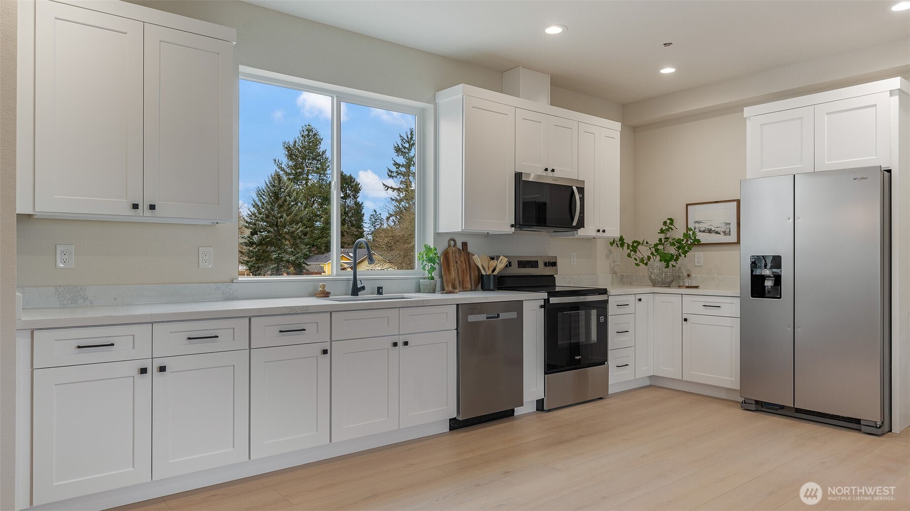 225 106th Street Southwest, Unit A2 Everett, WA 98204 - Photo 7 of 26 a kitchen with white cabinets and stainless steel appliances