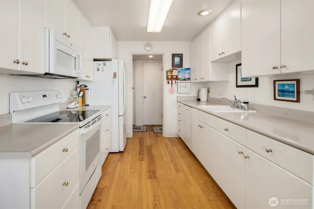 a large white kitchen with stainless steel appliances and white cabinets