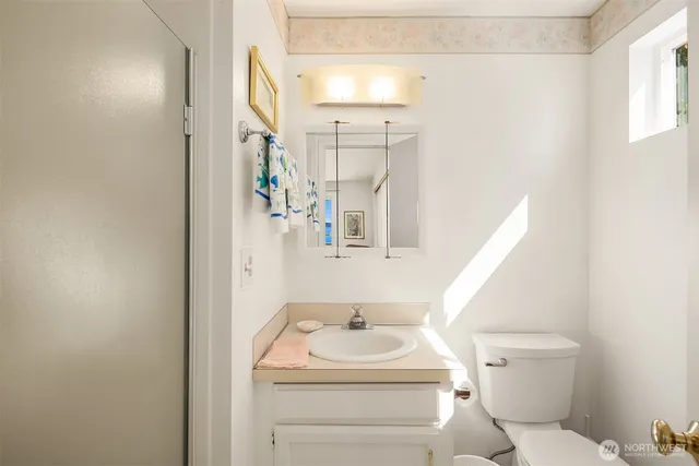 a bathroom with a sink a toilet and a mirror