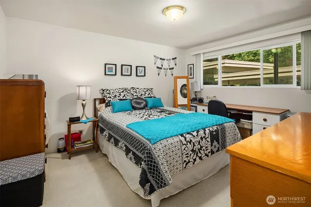 a bedroom with a bed and a dresser next to a window