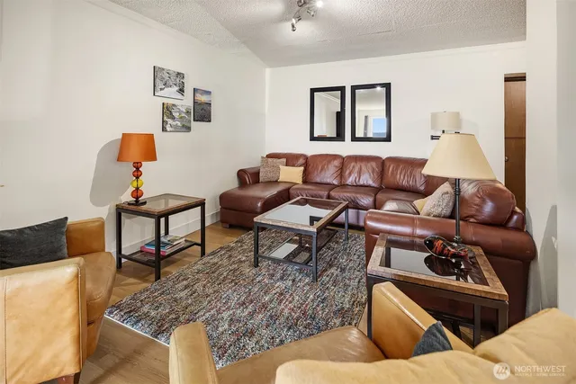 a living room with furniture wooden floor and a dining table