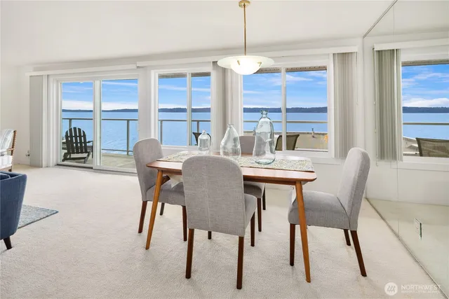 a kitchen with stainless steel appliances kitchen island granite countertop a table chairs and a refrigerator