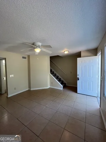 an empty room with fan and entryway