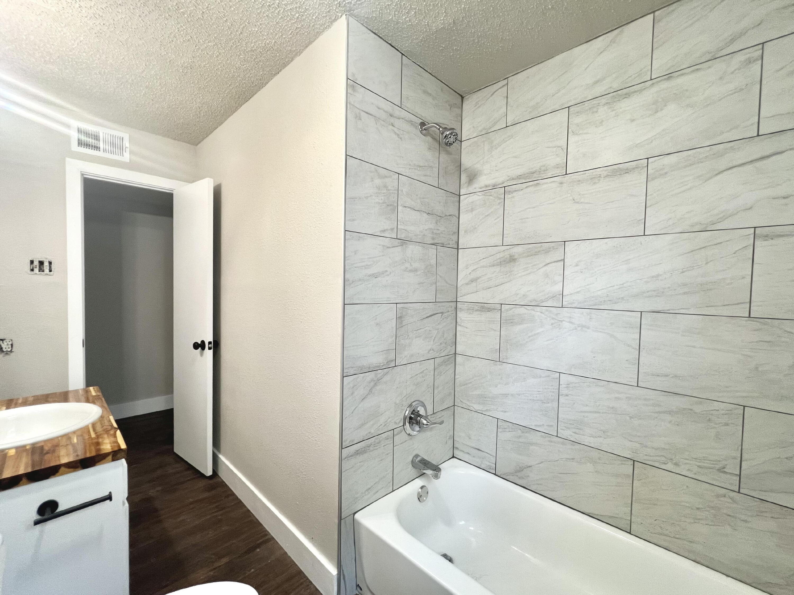 2620 25th Street Lubbock, TX 79410 - Photo 12 of 16 a bathroom with a tub a sink and a shower