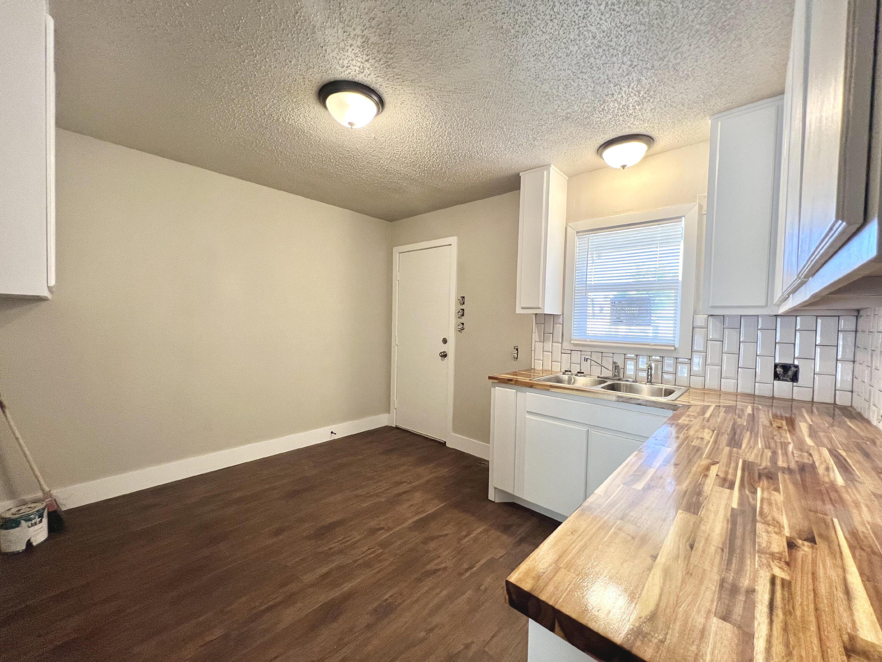 2620 25th Street Lubbock, TX 79410 - Photo 6 of 16 a view of a kitchen with a sink and dishwasher with wooden floor