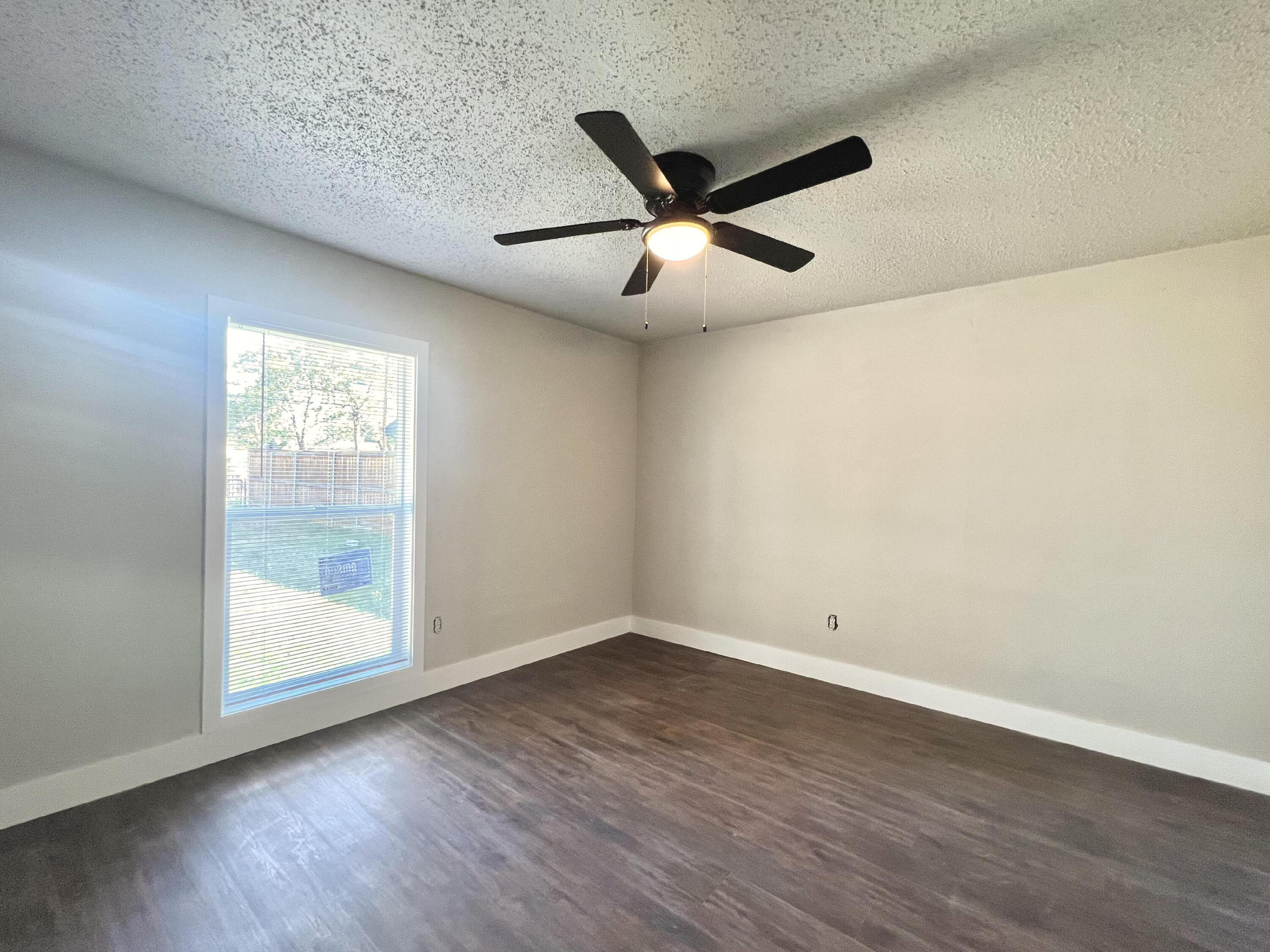 2620 25th Street Lubbock, TX 79410 - Photo 8 of 16 a view of empty room with wooden floor and fan