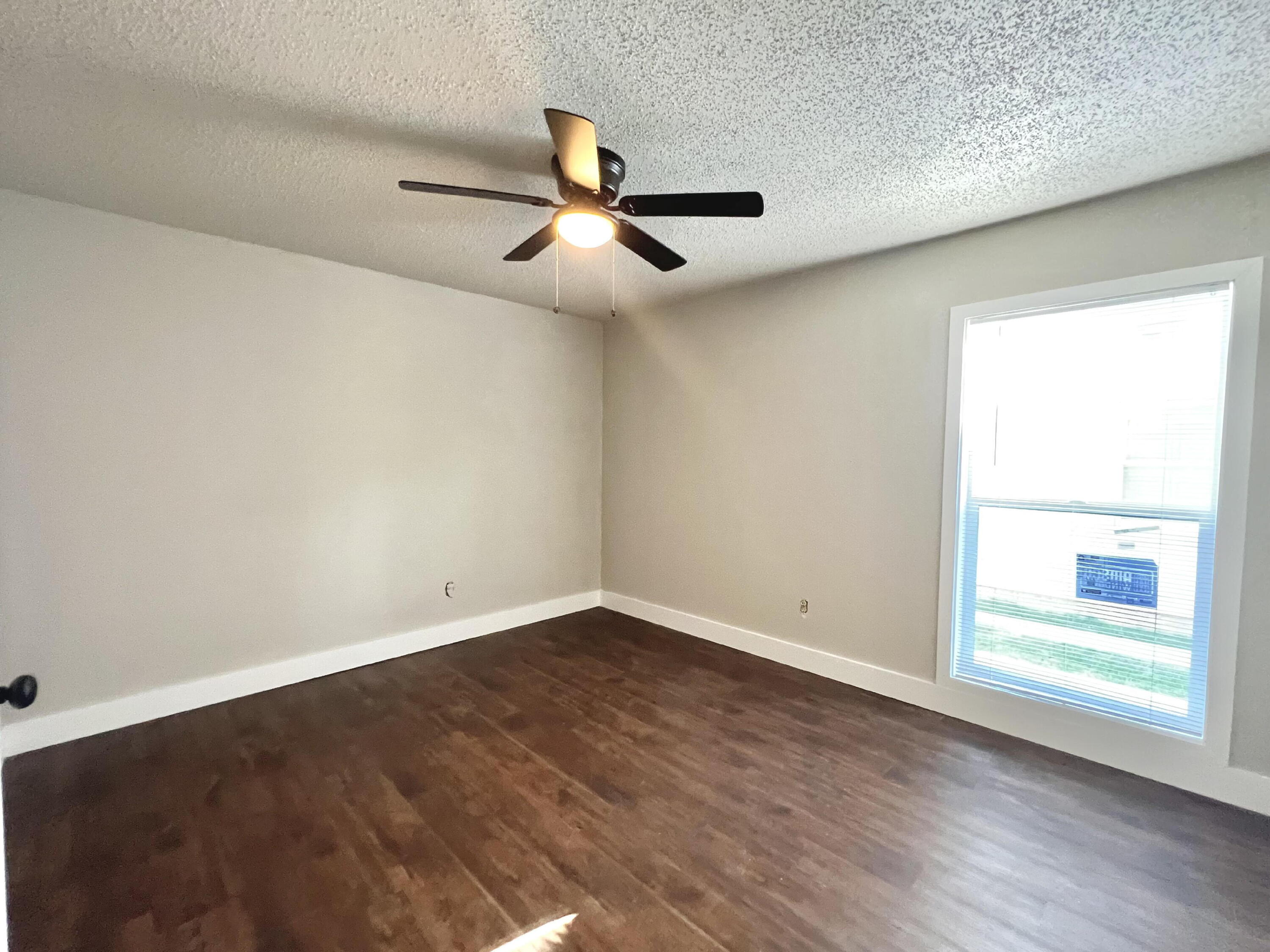 2620 25th Street Lubbock, TX 79410 - Photo 10 of 16 an empty room with wooden floor fan and windows
