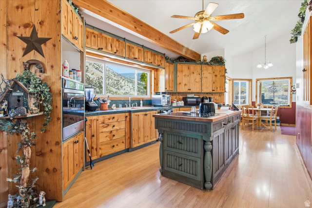 811 East Canyon Road Mayfield, UT 84643 - Photo 13 of 57 Kitchen featuring wood-finish cabinetry, a central island with a wood-finish countertop, stainless steel double wall ovens, wood-finish flooring, and exposed wood beams