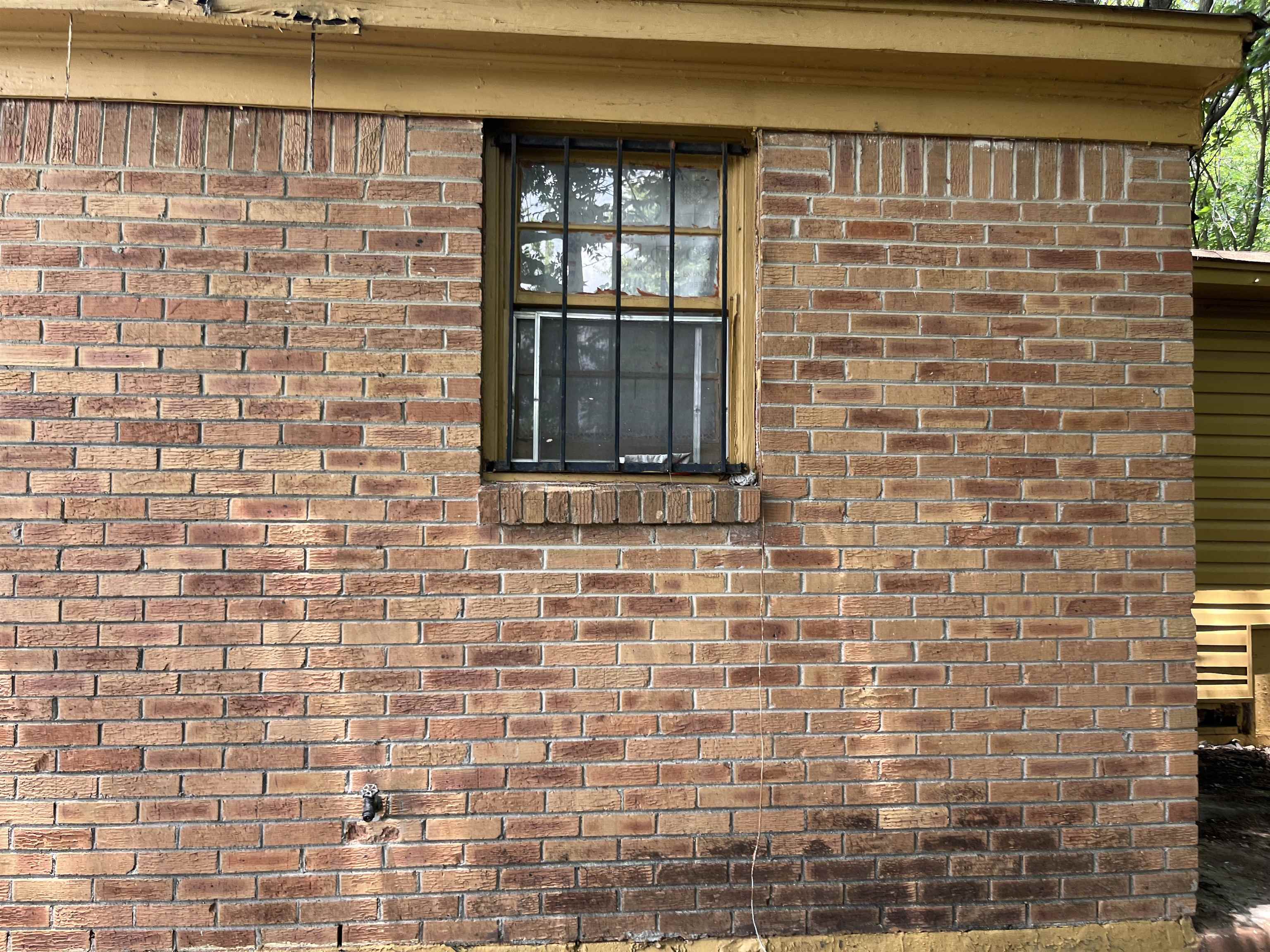 100 Silverage Avenue Memphis, TN 38109 - Photo 5 of 30 Brick exterior wall featuring a window with security bars