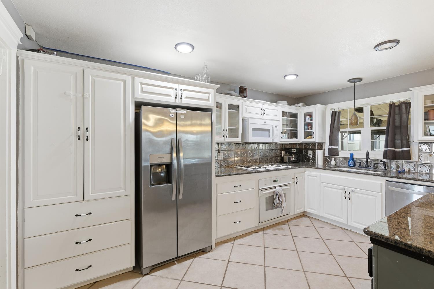 36313 Ave 12 Madera, CA 93636 - Photo 16 of 41 a kitchen with granite countertop cabinets and stainless steel appliances