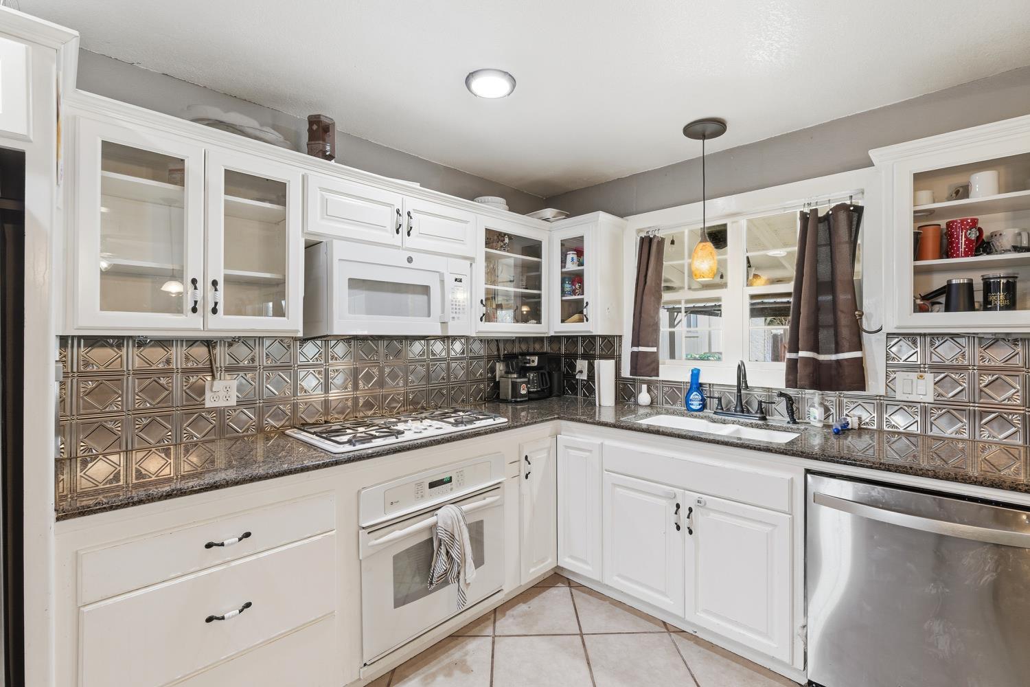36313 Ave 12 Madera, CA 93636 - Photo 17 of 41 a kitchen with granite countertop stainless steel appliances white cabinets and sink