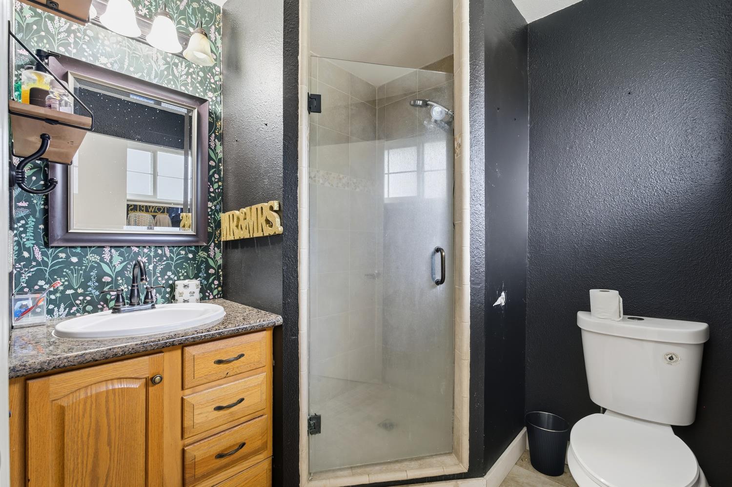 36313 Ave 12 Madera, CA 93636 - Photo 29 of 41 a bathroom with a granite countertop toilet sink and shower