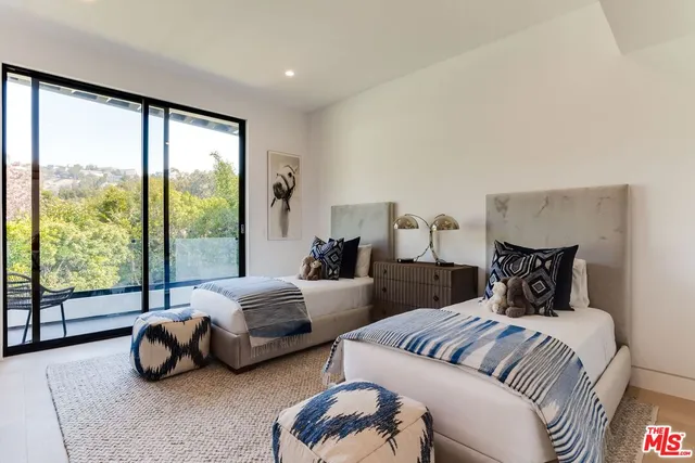 a spacious bedroom with a bed and a couch next to a window