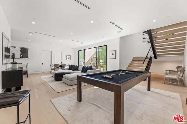 a living room with furniture a desk and a flat screen tv