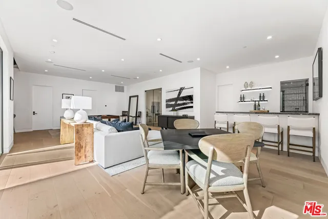 a living room with stainless steel appliances kitchen island granite countertop furniture and a dining table with kitchen view